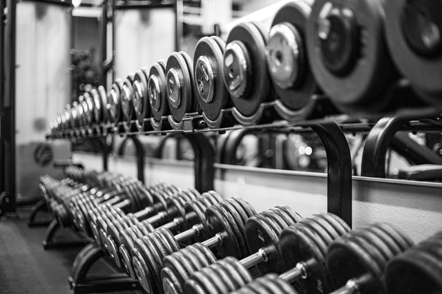 Dumbbells line up in their racking at the gym