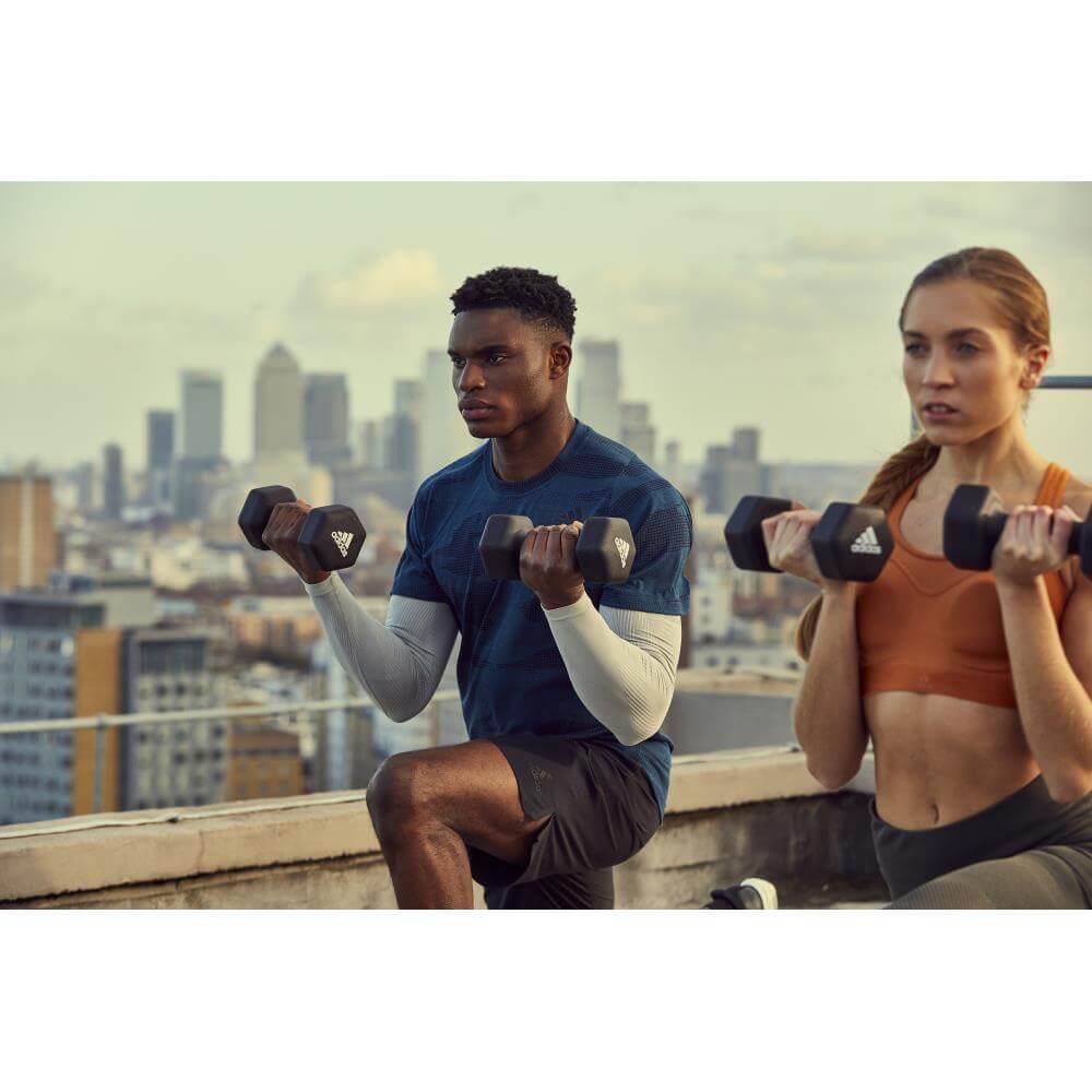 Man and woman holding adidas 3kg Dumbbells -performing a gym workout