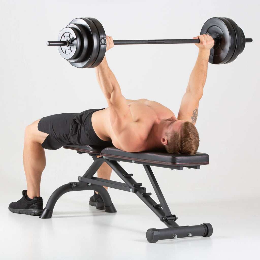 Man performing barbell bench press on a HXGN Ultimate Weight Bench 