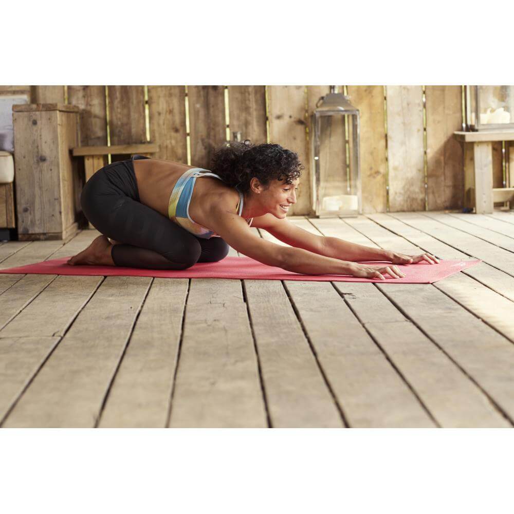 Woman doing a yoga pose on a Reebok 4mm Yoga Mat - Red