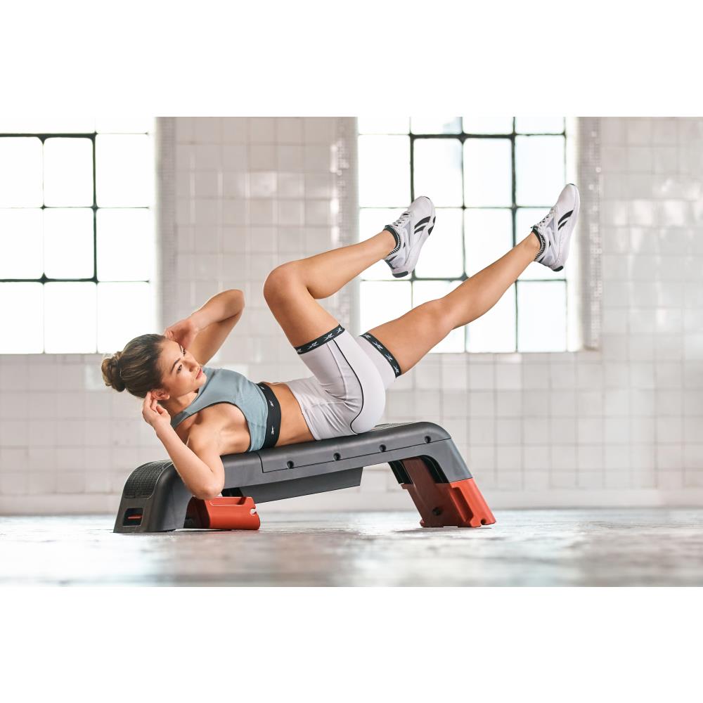 Woman performing ab training on a Reebok Deck Red