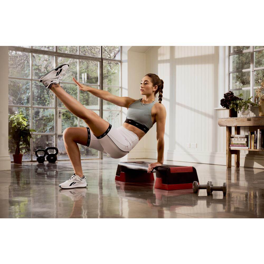 Woman performing Reebok Step Fitness Training home workout- Red