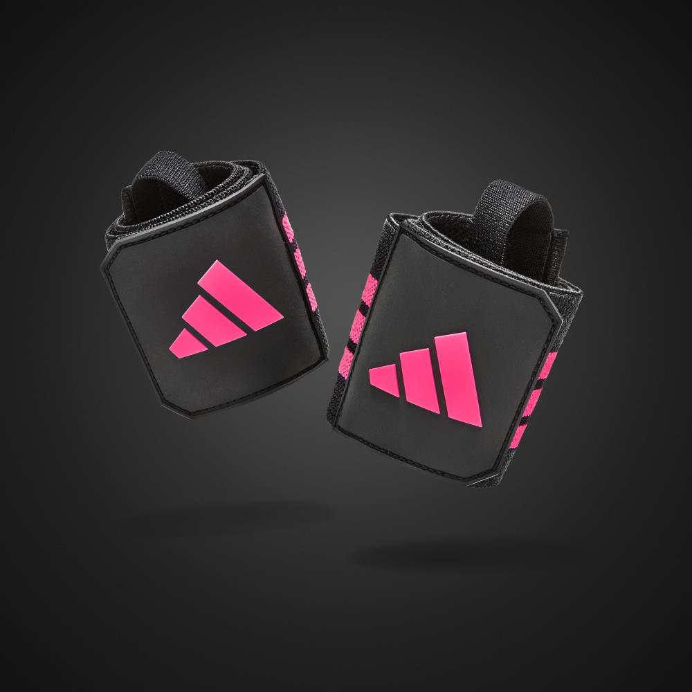 Black wrist wraps with pink Adidas logos on a dark background