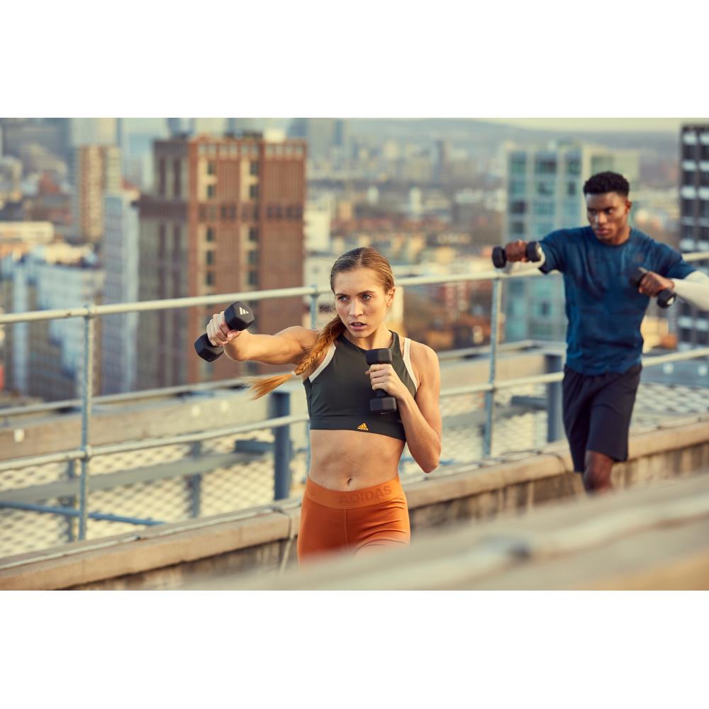 Two people exercising on a rooftop with cityscape in the background