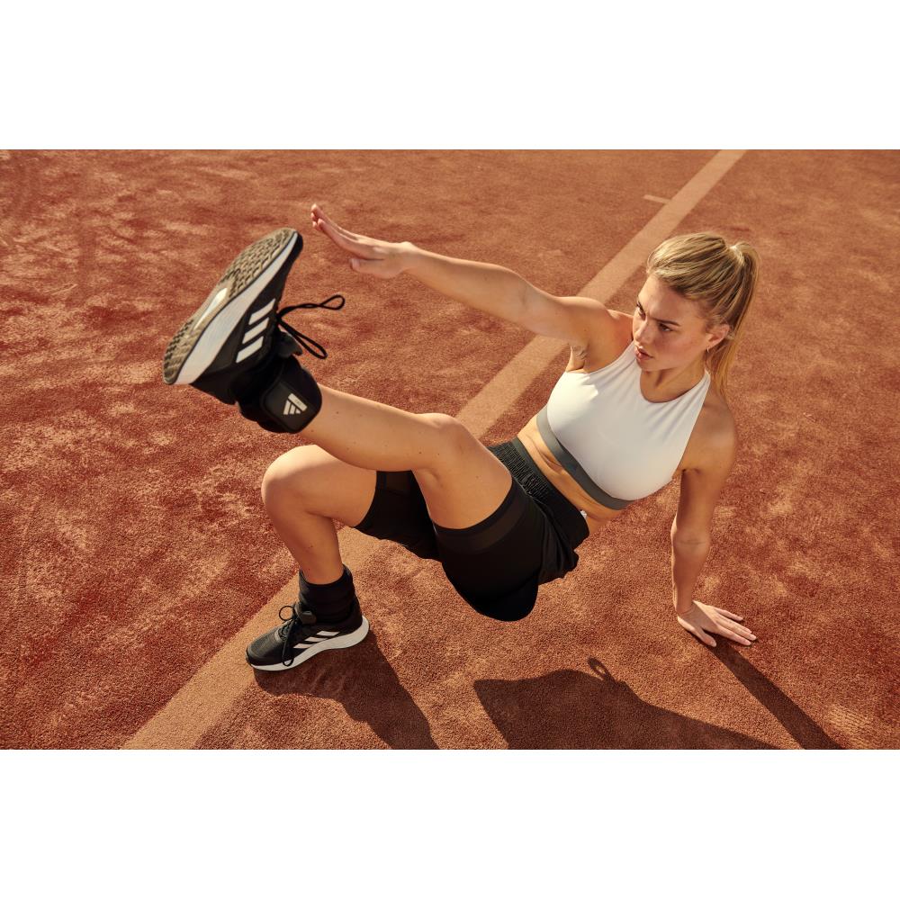 Woman exercising on a running track wearing Adidas 1kg ankle/wrist weights