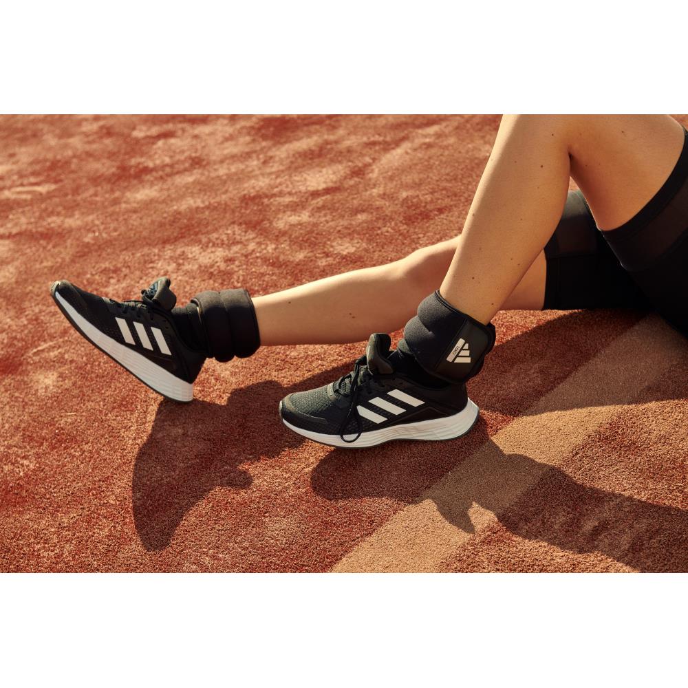 Person wearing black Adidas 1kg ankle/wrist weights