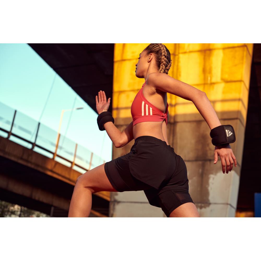 Woman in athletic wear running outdoors with the Adidas Ankle Wrist Training Weights 2 x 1kg