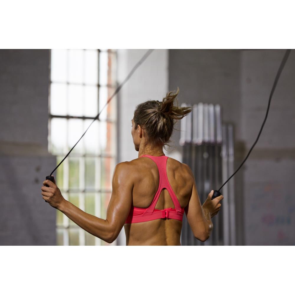 Woman exercising with jump ropes in a gym setting