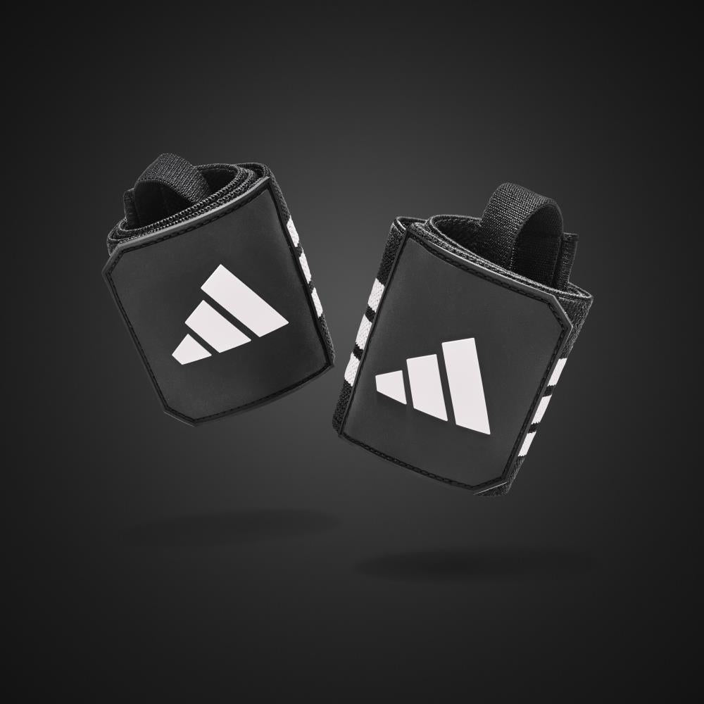 Black wrist wraps with white Adidas logo on a dark background