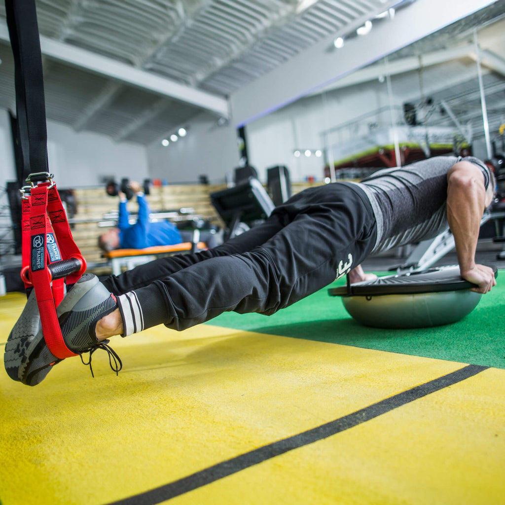 Person using suspension straps for exercise in a gym setting