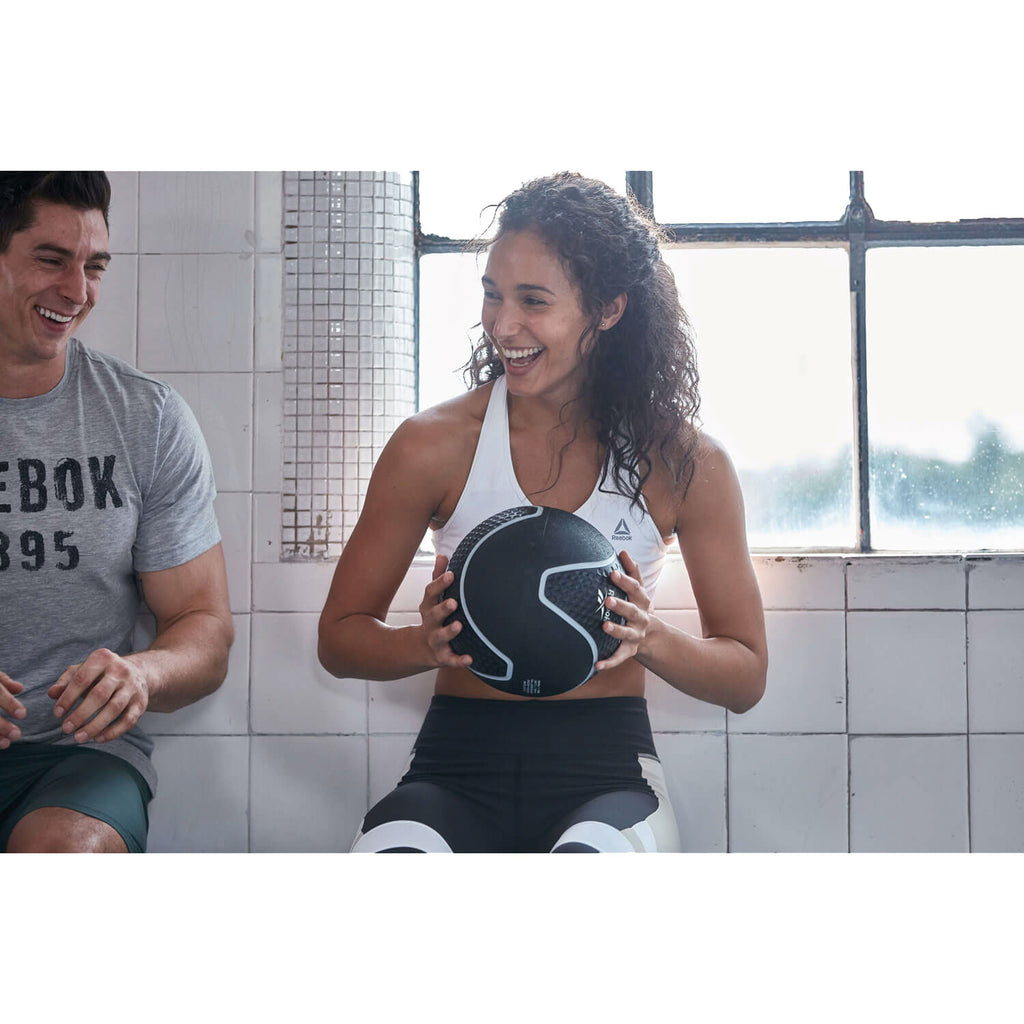 Woman using the Reebok 3kg Medicine Ball