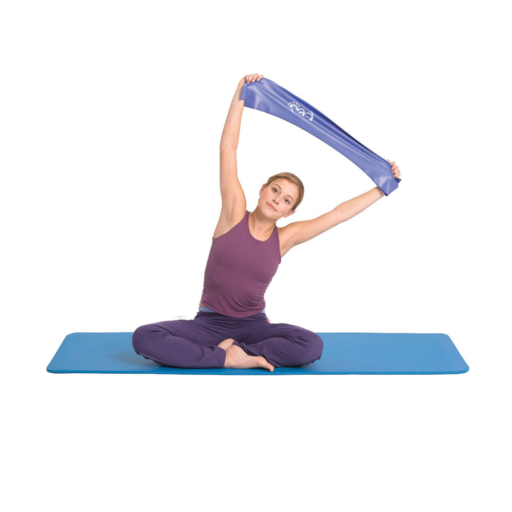 Woman exercising on a yoga mat using a Fitness Mad blue resistance band