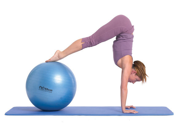Woman performing a hand stand with her feet resting on a Fitness Mad Studio Swiss Ball- 75cm
