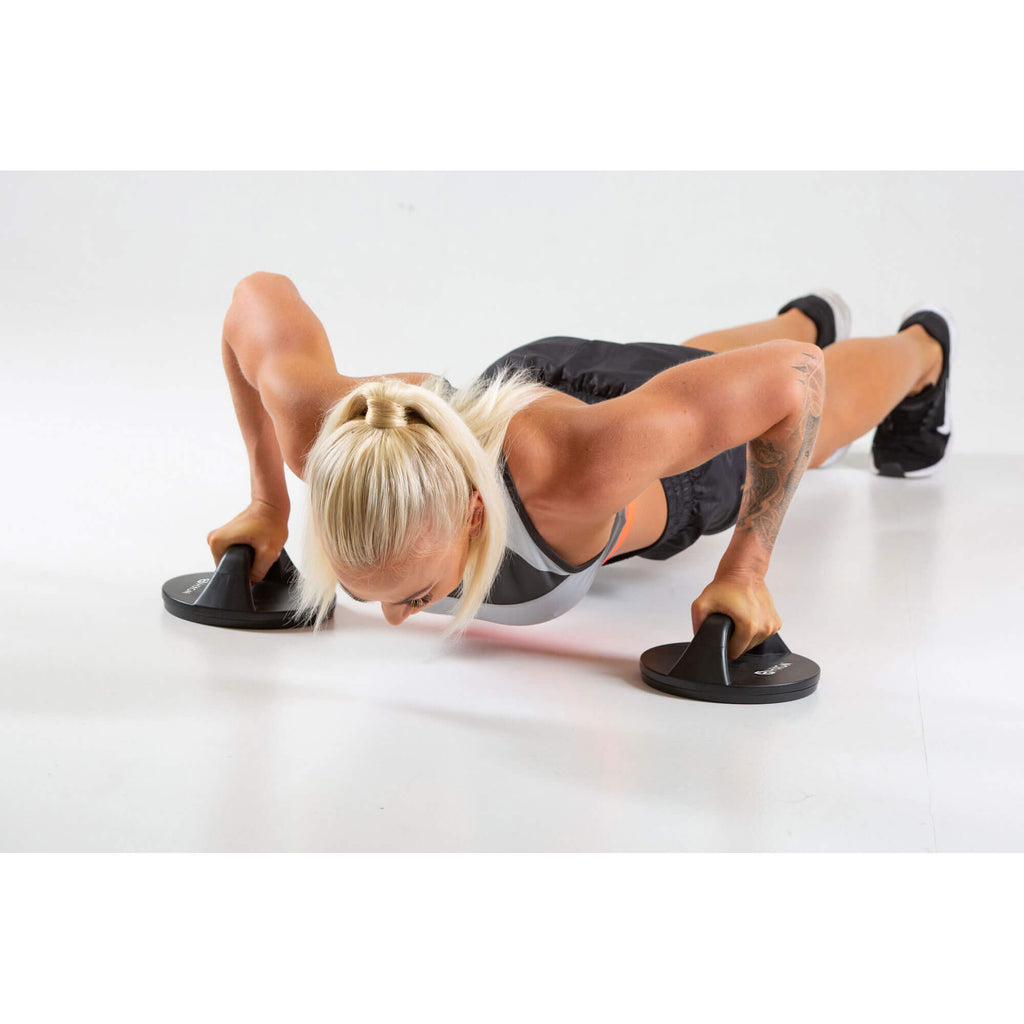 Woman performing push ups using HXGN Rotating Push Up Bars