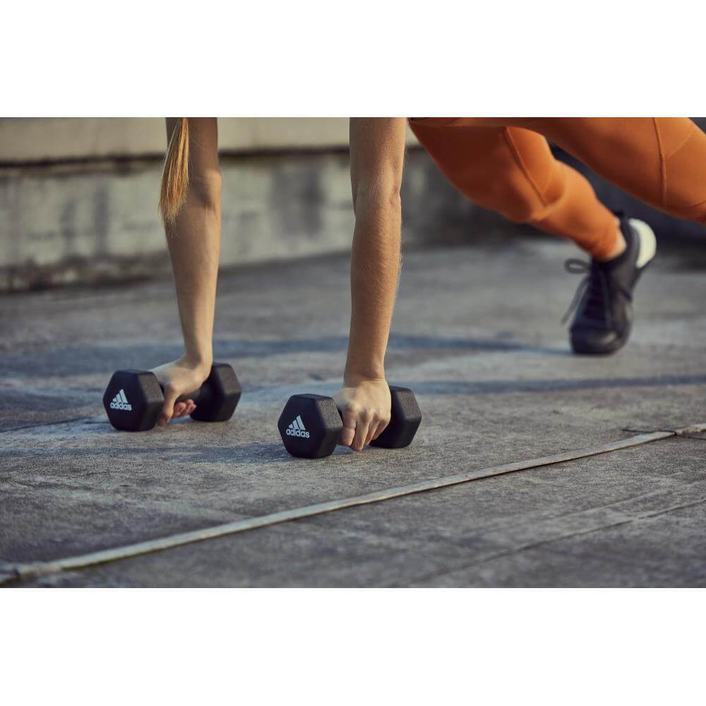 Woman holding adidas 3kg Dumbbells -performing a gym workout