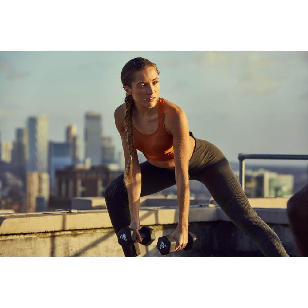 Woman performing workout with adidas-4kg-dumbbells