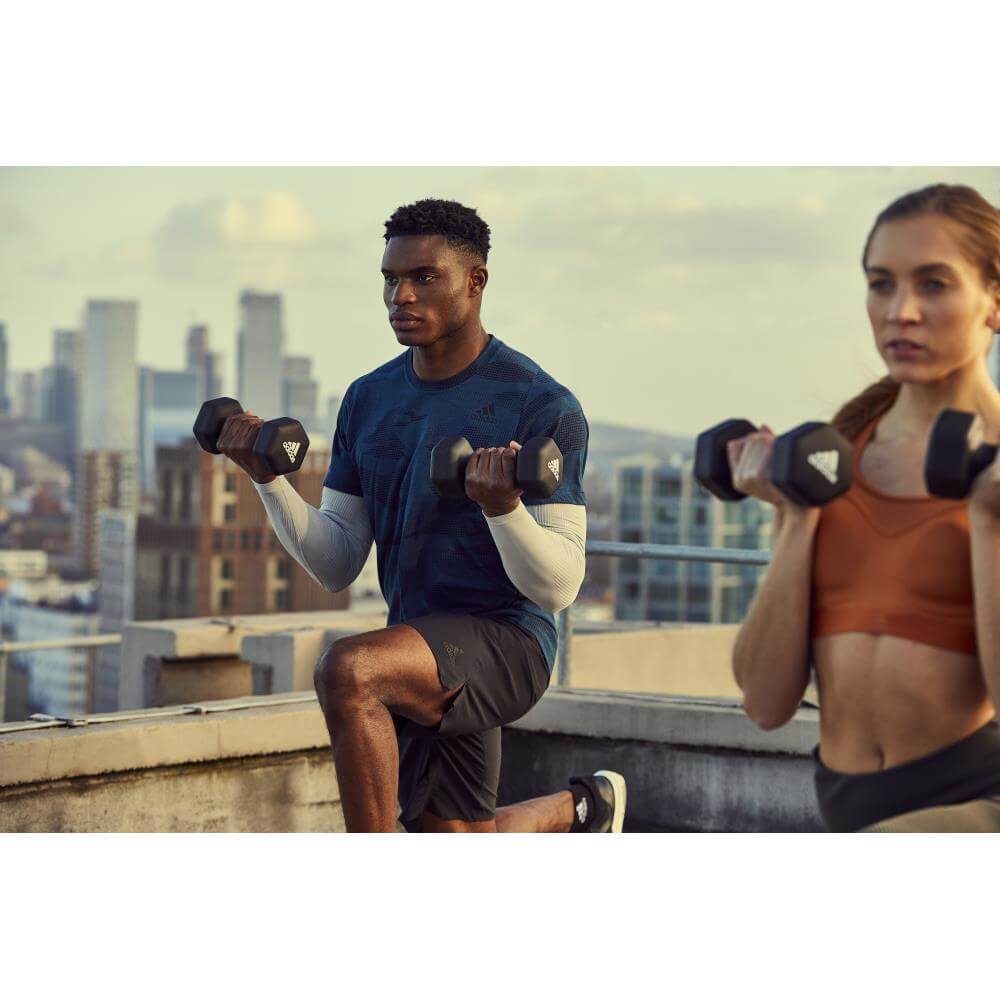 Man and woman doing full body workout using Adidas 5kg Dumbbells 