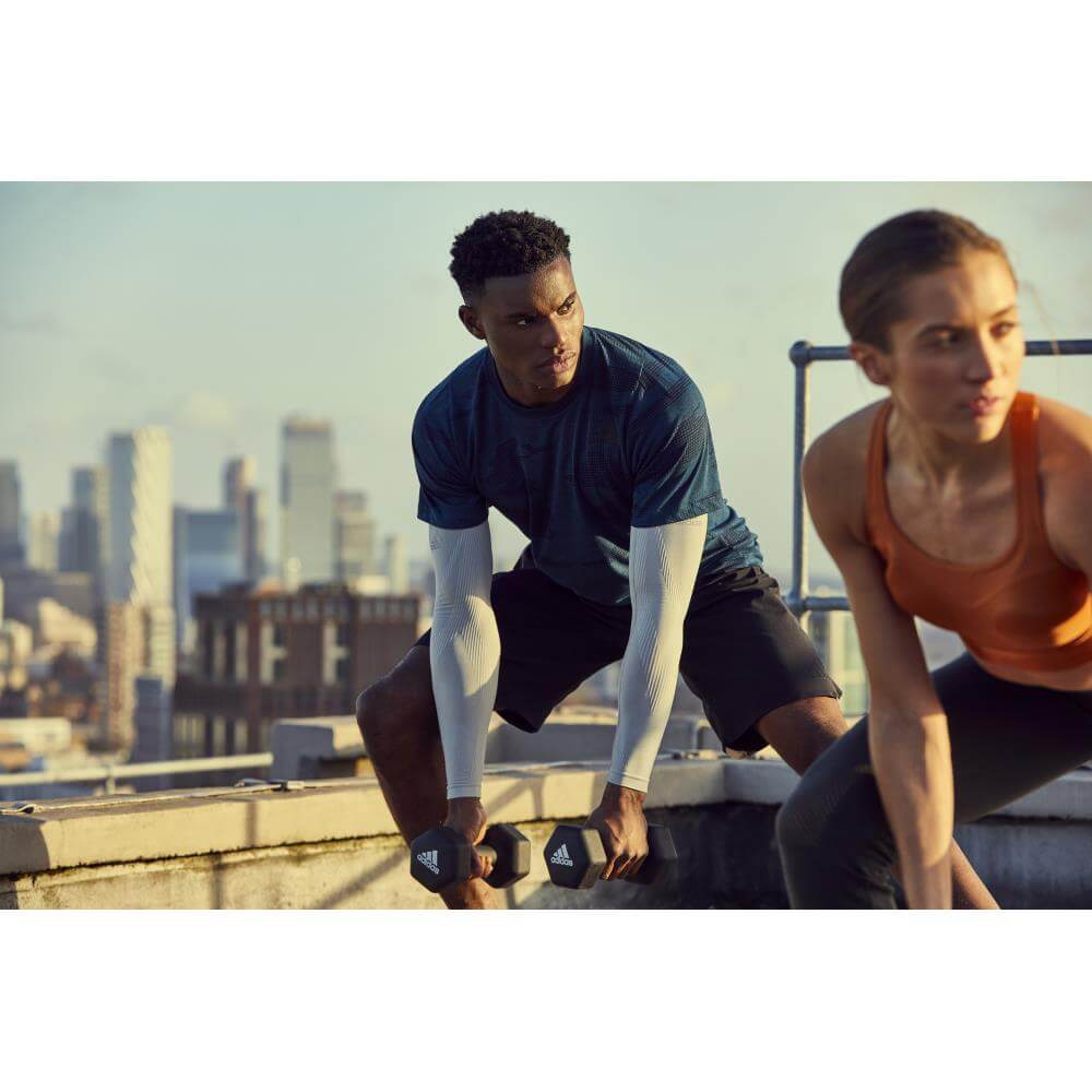 Man and woman exercising with Adidas 5kg Dumbbells