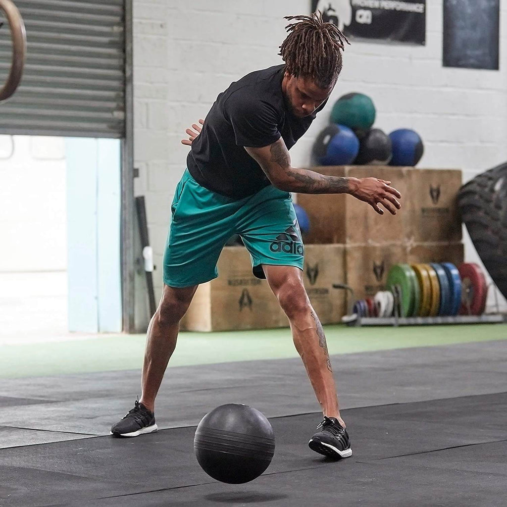 Man slamming an Adidas 5kg Slam Ball onto the gym floor - Explosive Training