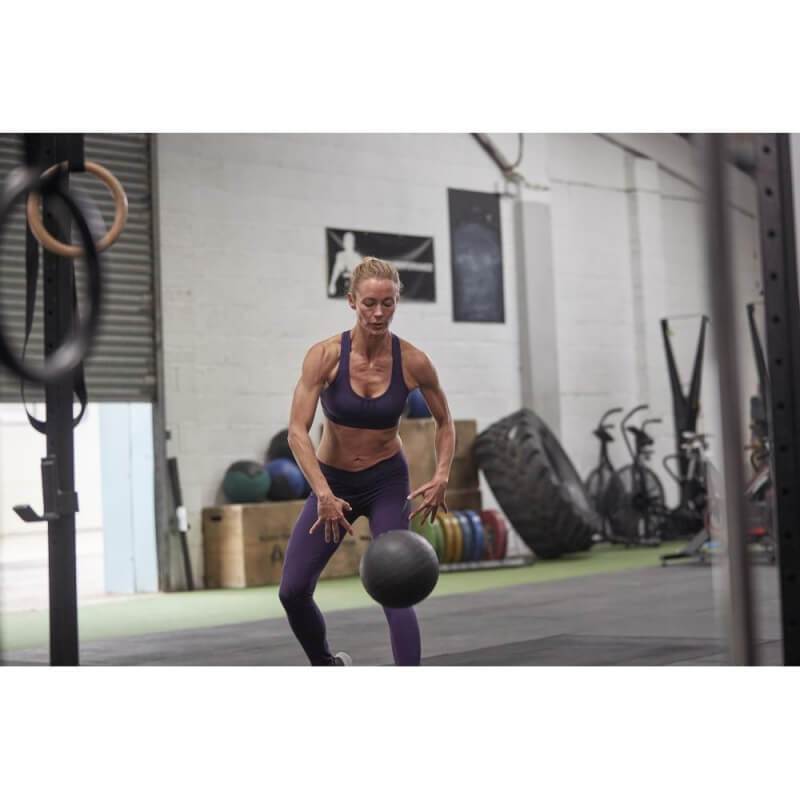 Woman slamming and adidas 5kg slam ball onto the gym floor