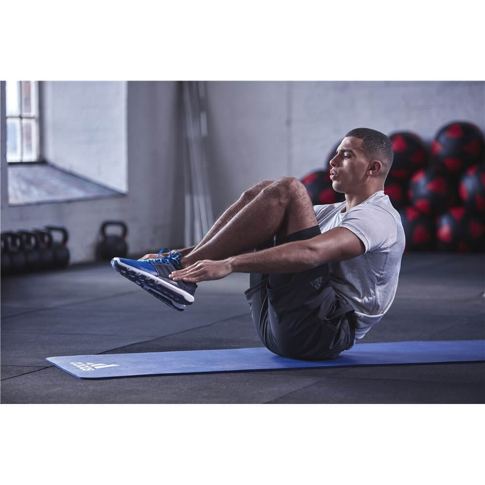 Man exercising in the gym on an Adidas 7mm Training Mat - Blue