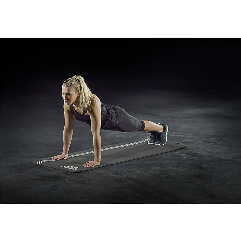 Woman performing a plank on and adidas elite training mat - grey/white