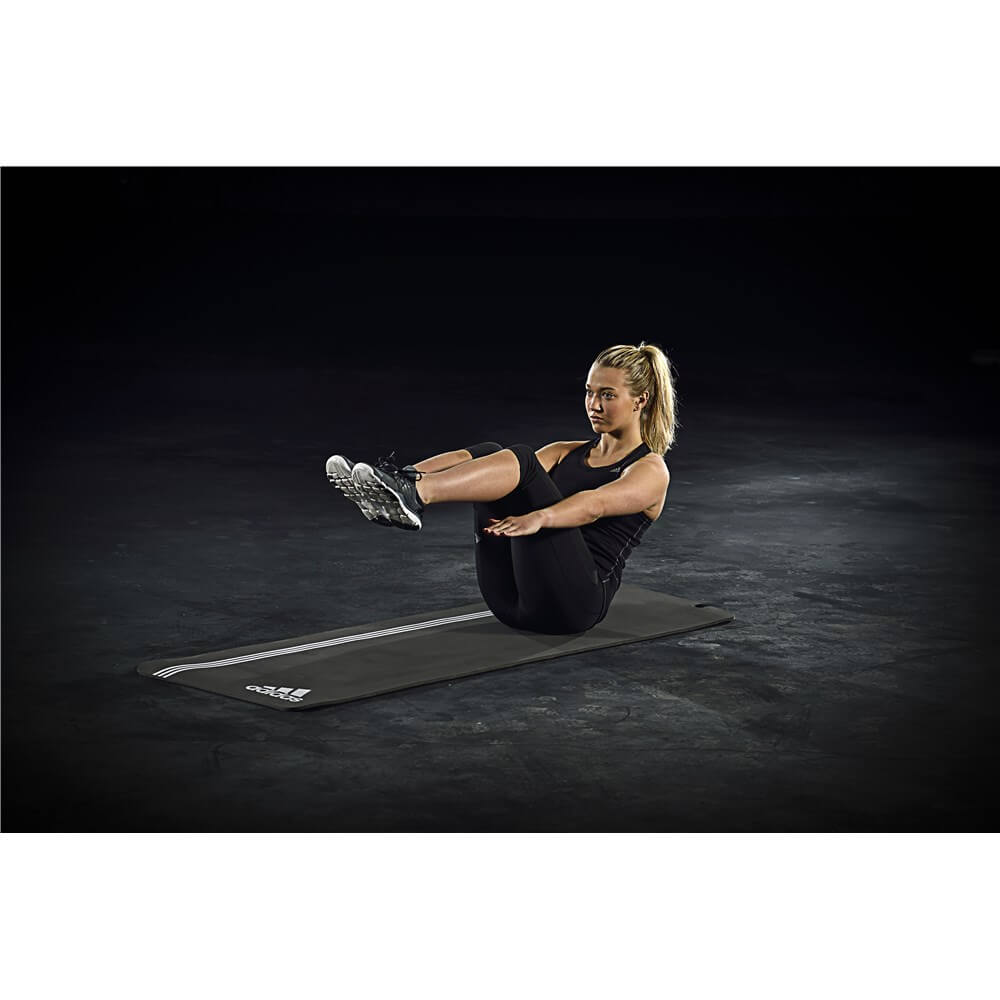Woman exercising on an adidas elite training mat - grey/white