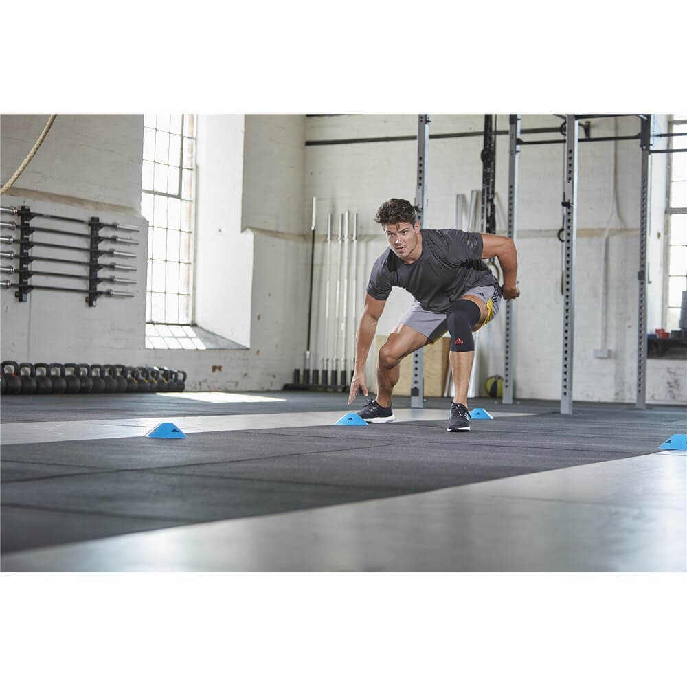 Man exercising in the gym wearing an Adidas Knee Support 