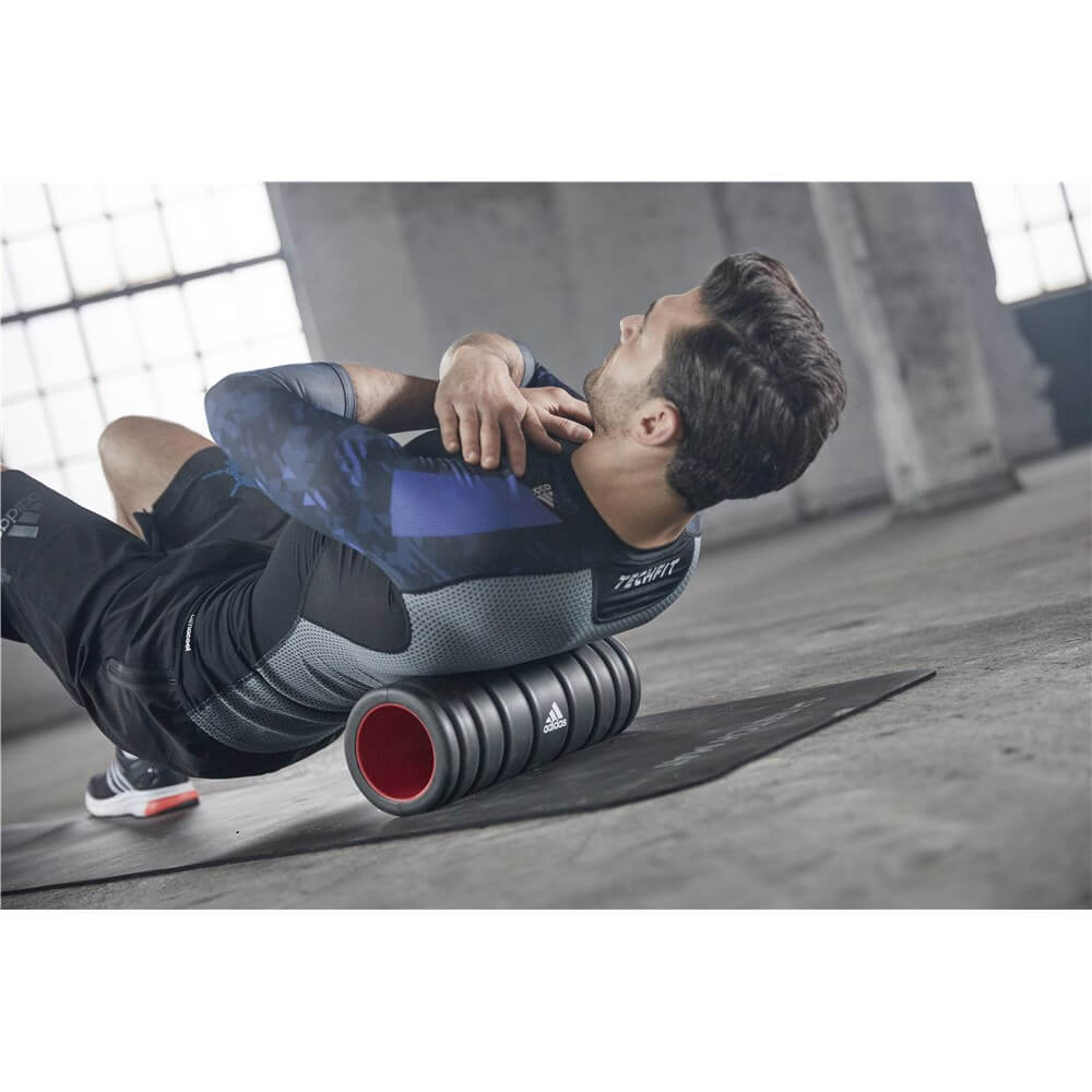 Man foam rolling on an Adidas Stretch Mat 