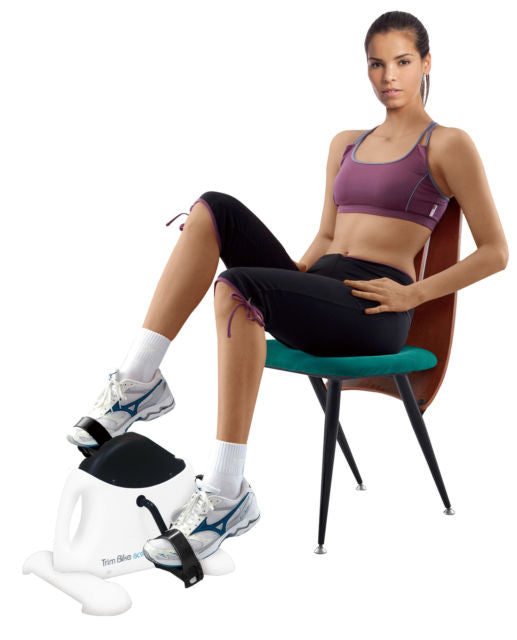 Woman sitting on a chair whilst using a body-sculpture-bc903-mini-exercise-bike