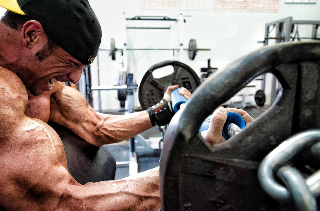 Strong man performing preacher curls using Fat Gripz Blue