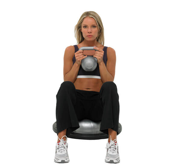 Woman exercising using a Fitness Mad 5kg PVC Kettlebell