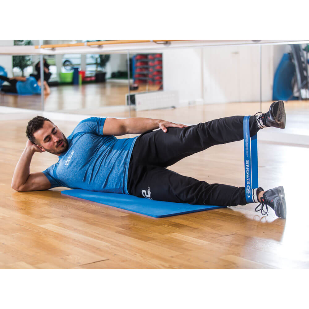 Man exercising in the gym with Fitness Mad Mini Strong around his calves