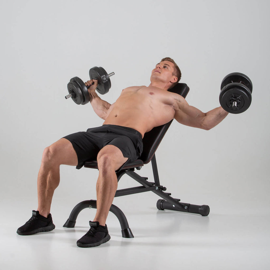 Man performing chest flyes on a HXGN Ultimate Dumbbell Weight Bench 