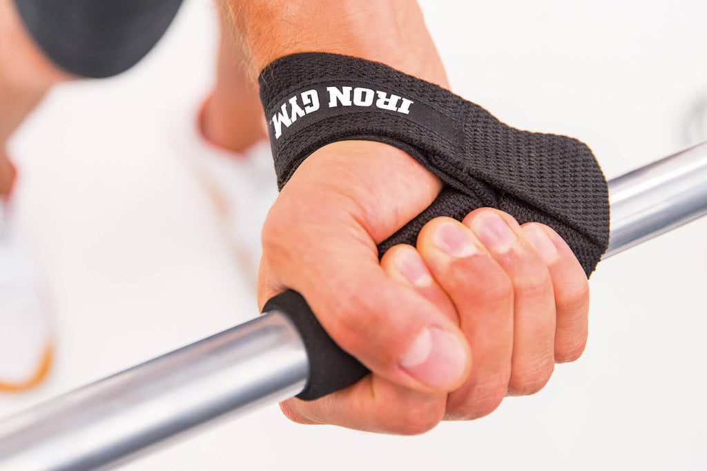 Man's hand gripping a barbell whilst wearing an Iron Gym Lifting Strap