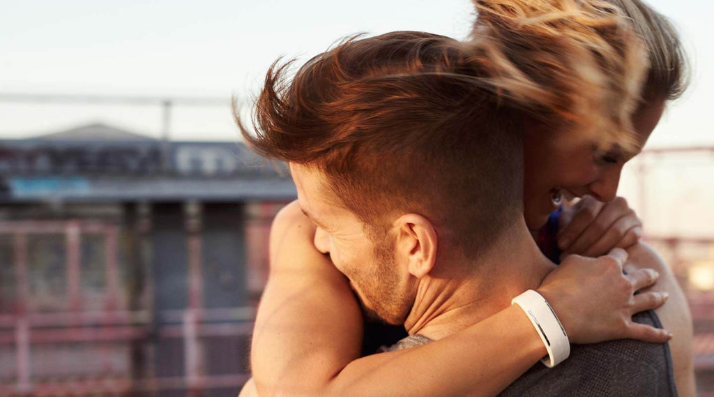 Man an woman hugging. Woman is wearing a white Polar Loop 2 Activity Tracker