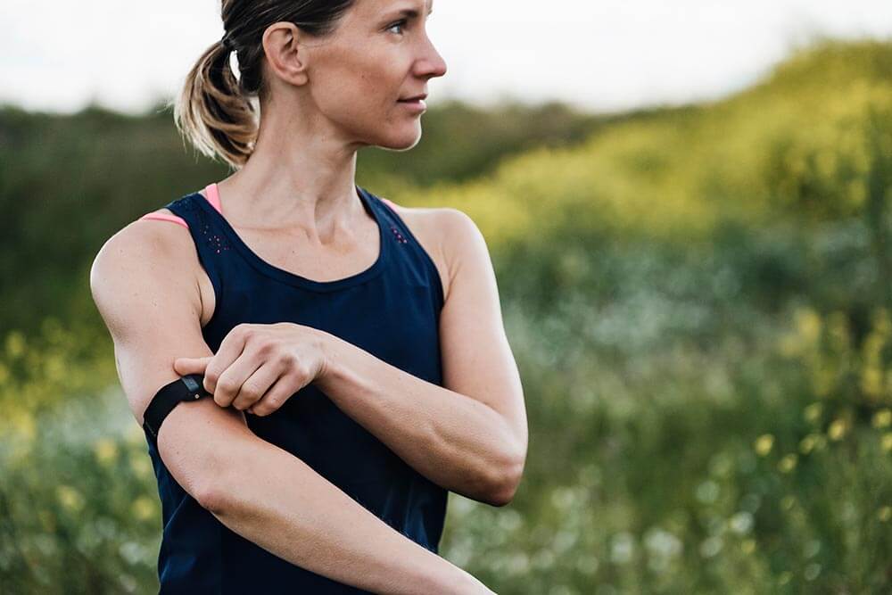 Woman out running wearing a Polar OH1 Arm Heart Rate Monitor