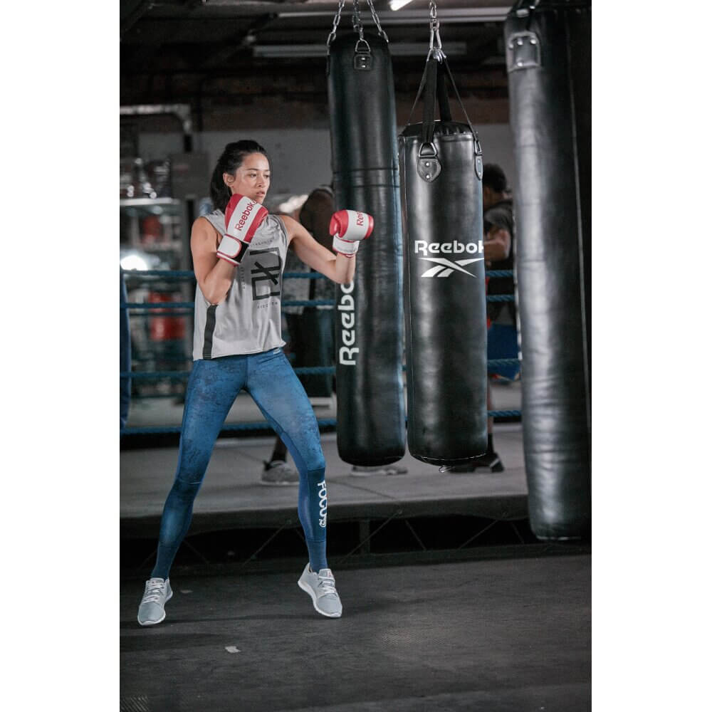 Woman punching a Reebok 4ft PU Boxing Punch Bag - Black/White