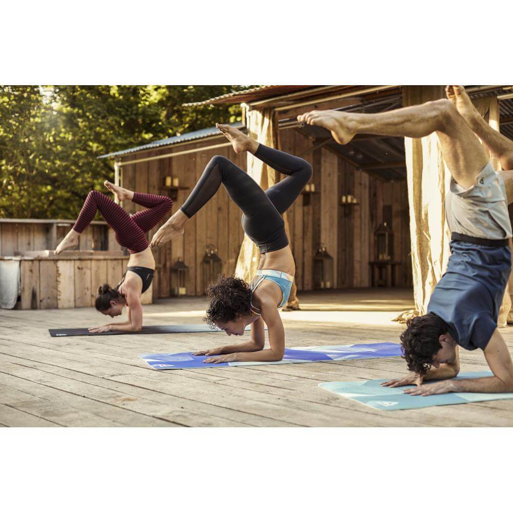 People performing a yoga pose on Reebok 4mm POE Yoga Mats