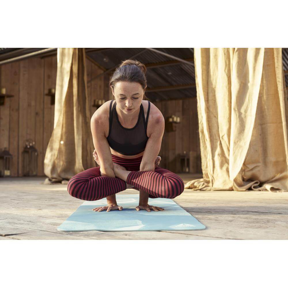 Woman performing a yoga pose on a Reebok 4mm POE Yoga Mat