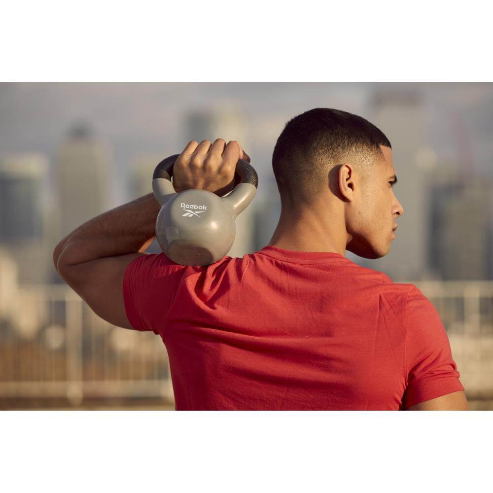 Man holding a Reebok 8kg Cast Iron Kettlebell on his shoulder