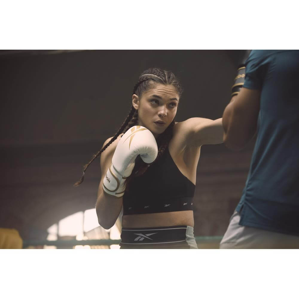 Reebok Woman punching wearing Boxing Gloves - White and Gold 