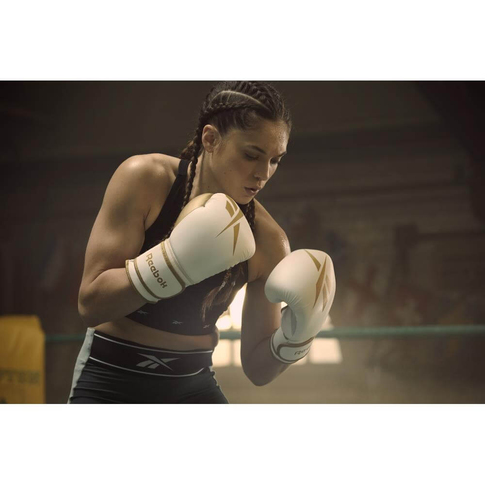 Woman boxing training wearing Reebok Boxing Gloves - White and Gold 