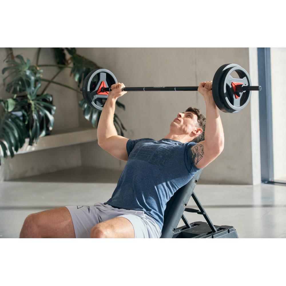 Man weight lifting on a Reebok Deck Weight Bench - Red