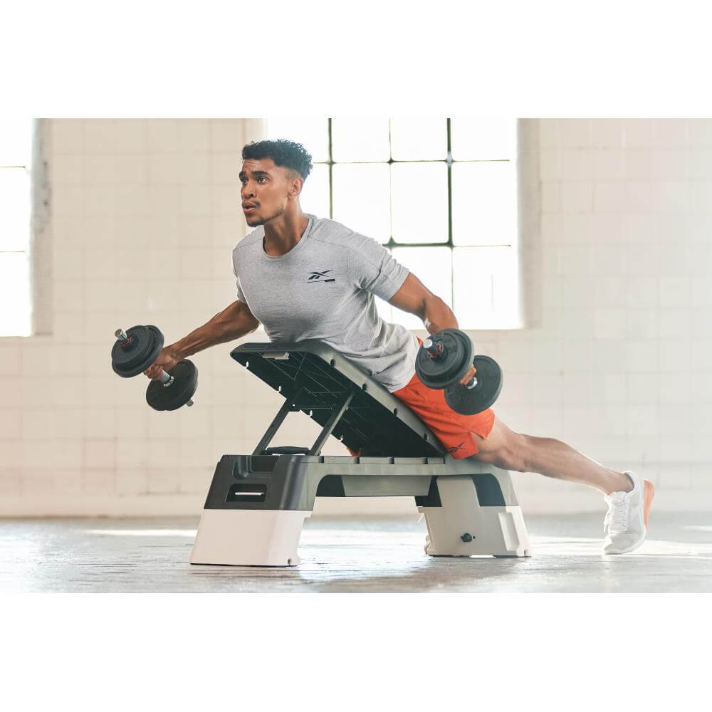 Man performing chest flys on a Reebok Deck Incline Weight Bench - White
