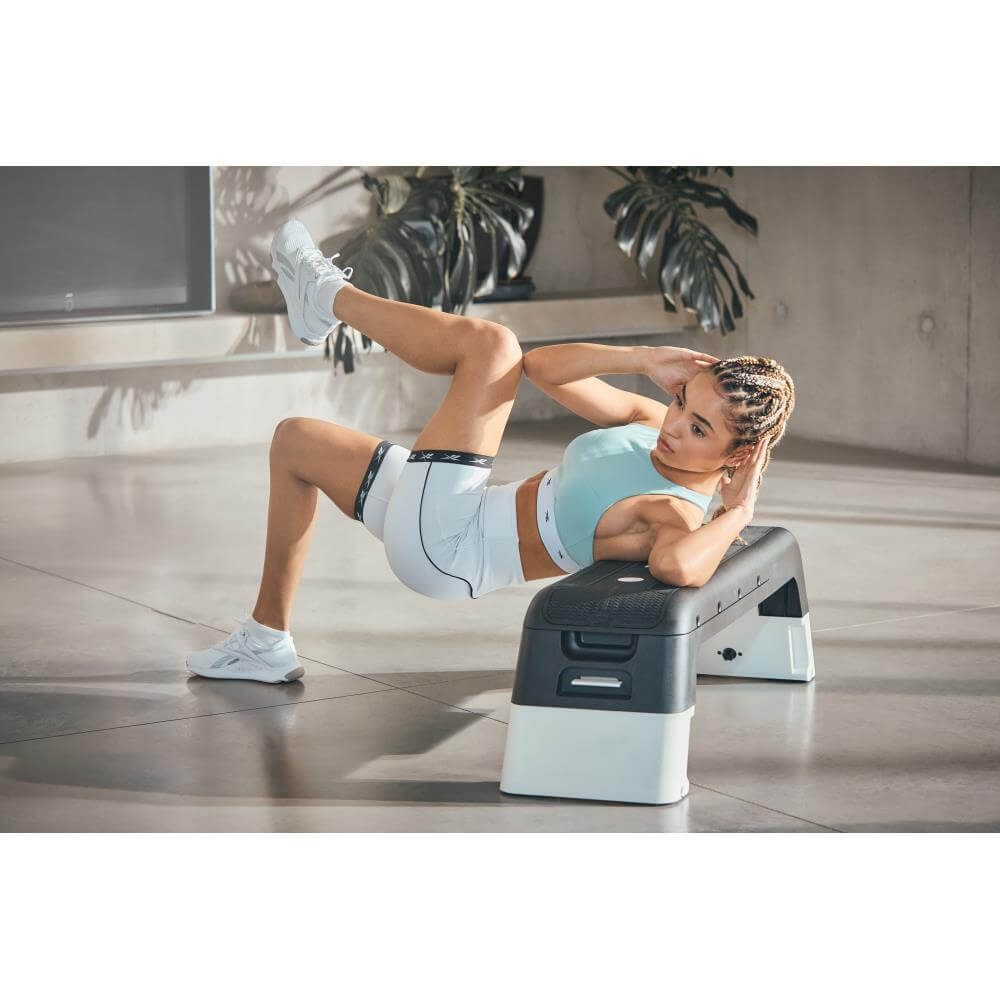 Woman using a Reebok Deck Home Abdominal Training - White