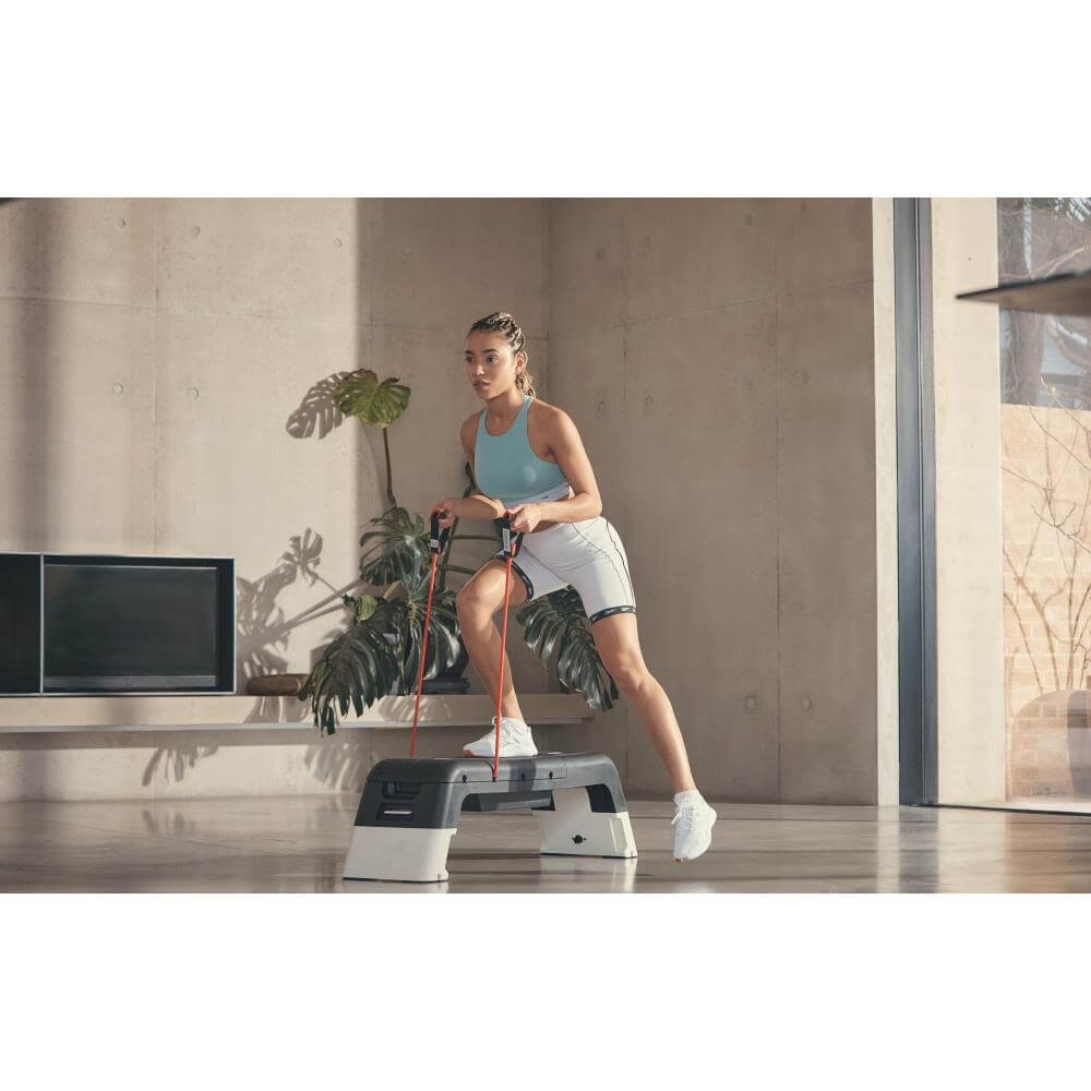 Woman performing a Reebok Deck Resistance Tube Workout - White