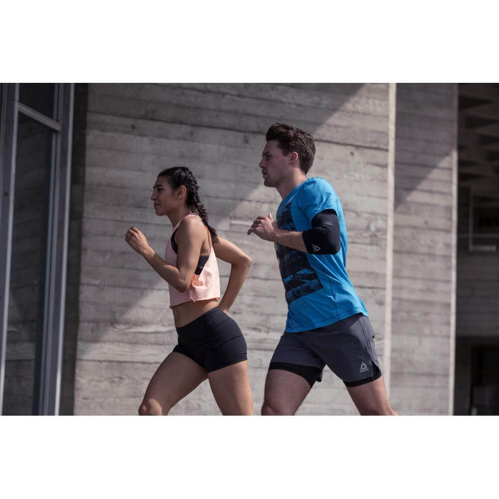 Two runners - one is wearing a Reebok Elbow Support