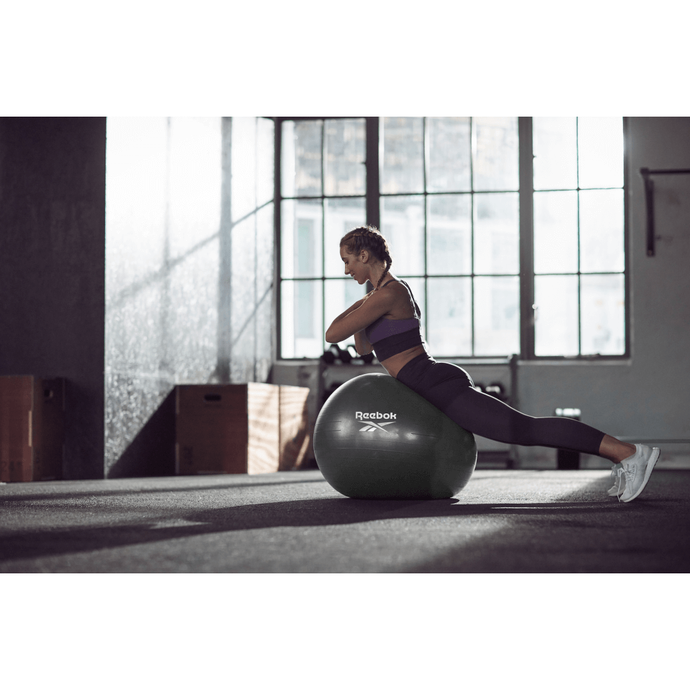 Woman using Reebok 75cm Gym Ball