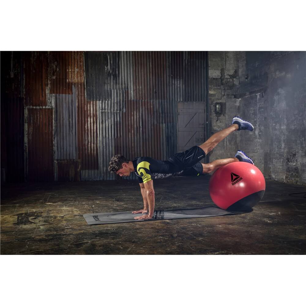 Man exercising on a Reebok Mens Training Stability Gym Ball - 65cm